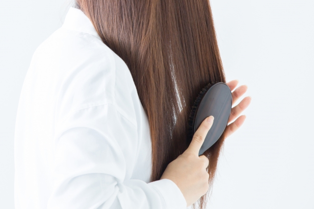 女性が髪をクシでとかす様子