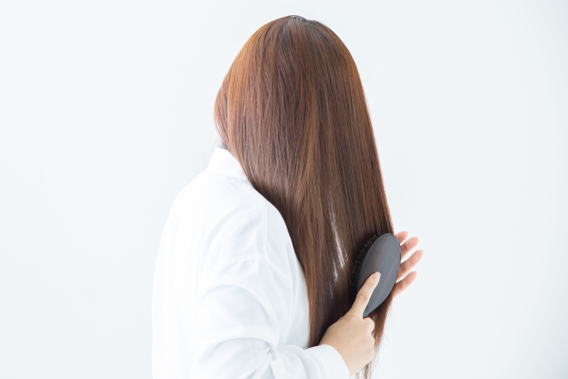 髪をクシでとかす女性