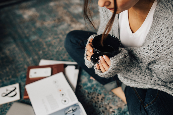 コーヒーを飲みながら雑誌を読む女性