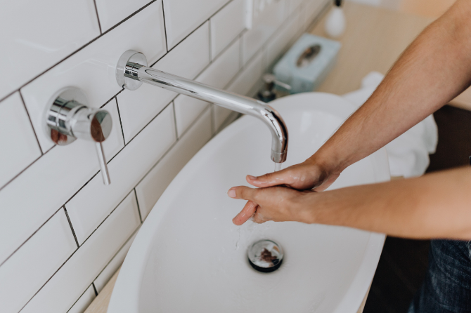 男性が水道で手を洗っている様子