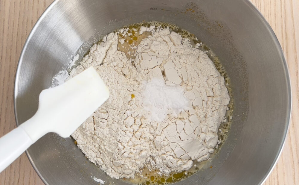 かぼちゃ蒸しパンの生地に小麦粉を入れて混ぜる