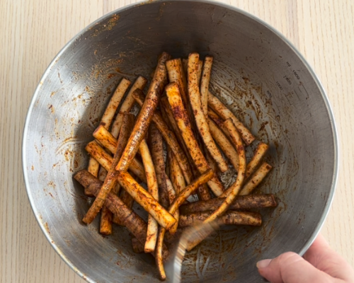 ごぼうスティックにスパイスをまぶす